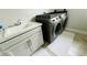 Bright laundry room features a sink, built-in cabinets, and modern washer and dryer at 13706 Werrington Dr, Winter Garden, FL 34787