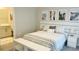 Spacious bedroom with white bed, bench, and travel-themed artwork at 13706 Werrington Dr, Winter Garden, FL 34787