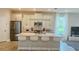 Modern kitchen with island, white quartz countertops, and stainless steel appliances at 13706 Werrington Dr, Winter Garden, FL 34787
