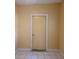 Simple interior room with a yellow wall and a closed door at 107 E Cypress St, Kissimmee, FL 34744