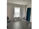 Spacious bedroom with grey wood-look floors and window at 1523 Wynford Cir, Tavares, FL 32778