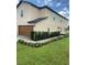 Tan two-story house with brown garage door and landscaped lawn at 1523 Wynford Cir, Tavares, FL 32778