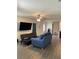 Living room with blue couch and a large TV at 1523 Wynford Cir, Tavares, FL 32778