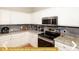 Fully equipped kitchen with stainless steel appliances and granite countertops at 443 Corvina Dr, Davenport, FL 33897