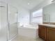 Bathroom with corner soaking tub, shower, and wood cabinets at 744 Stonewyk Way, Kissimmee, FL 34744