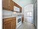 Kitchen features wood cabinets, a microwave, and an electric stove at 744 Stonewyk Way, Kissimmee, FL 34744