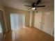 Bright bedroom with wood flooring, ceiling fan, and mirrored closet doors at 4009 Shannon Brown Dr, Orlando, FL 32808