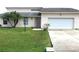 House exterior featuring a one-car garage and palm trees at 348 Jacksonville Ct, Kissimmee, FL 34759