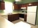 L-shaped kitchen with wood cabinets and white appliances at 348 Jacksonville Ct, Kissimmee, FL 34759
