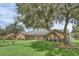 Brick ranch house with mature landscaping and tree at 4147 Boggy Creek Rd, Kissimmee, FL 34744