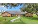 Brick ranch home with a manicured lawn and walkway at 4147 Boggy Creek Rd, Kissimmee, FL 34744
