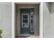 Modern gray front door with glass sidelights and brick walkway at 280 Pendant Ct, Kissimmee, FL 34747