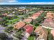 Aerial view showcasing a neighborhood with houses, streets, and a lake at 722 Coronado Dr, Kissimmee, FL 34759
