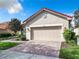 Tan house with red tile roof and a 2-car garage at 722 Coronado Dr, Kissimmee, FL 34759