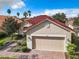 Tan house with red tile roof, 2-car garage, and brick paver driveway at 722 Coronado Dr, Kissimmee, FL 34759