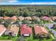 Aerial view of a residential area featuring houses with red tile roofs and a tree-lined street at 722 Coronado Dr, Kissimmee, FL 34759