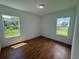 Bedroom with wood floors and two windows offering natural light at 1204 Vero Beach Way, Poinciana, FL 34759