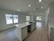 Modern kitchen island with white quartz countertops and light wood cabinets at 1204 Vero Beach Way, Poinciana, FL 34759