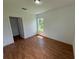 Bedroom with wood flooring, window, and access to a closet at 1204 Vero Beach Way, Poinciana, FL 34759