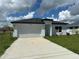 Modern, single story home with a white garage door and driveway at 1204 Vero Beach Way, Poinciana, FL 34759