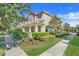 Two-story townhome with red and beige accents, landscaping, and walkway at 2917 Windmill Dr, Kissimmee, FL 34741