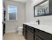 Clean bathroom with dark vanity, white countertop, and a window at 2917 Windmill Dr, Kissimmee, FL 34741