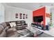 Living room with brown leather sectional sofa, large TV, and red accent wall at 2917 Windmill Dr, Kissimmee, FL 34741