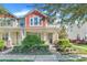 Two-story townhome with red and beige accents, front porch, and landscaped yard at 2917 Windmill Dr, Kissimmee, FL 34741