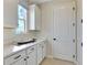 Bright laundry room with white cabinets and quartz countertops at 510 Summit River Dr, Apopka, FL 32712
