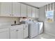 Bright laundry room, featuring white cabinets, a countertop sink, and a washer and dryer at 510 Summit River Dr, Apopka, FL 32712