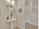 Clean powder room with pedestal sink and round mirror at 274 Captiva Dr, Davenport, FL 33896