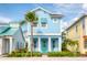 Charming light blue two-story home with teal door and palm tree at 3037 Sea Plane Ln, Kissimmee, FL 34747
