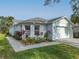 White house with gray roof, landscaping, and paved walkway at 205 Bell Tower W Xing, Kissimmee, FL 34759