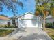 White house with gray roof and a two-car garage at 205 Bell Tower W Xing, Kissimmee, FL 34759