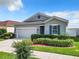 Gray one-story house with two-car garage, landscaping, and a paved driveway at 492 Buchannan Dr, Davenport, FL 33837