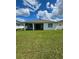 House's back exterior featuring a screened patio and green lawn at 1837 Hickory Bluff Rd, Kissimmee, FL 34744