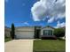 Single-story house with a two-car garage and landscaped lawn at 1837 Hickory Bluff Rd, Kissimmee, FL 34744