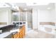 Elegant bathroom with double sinks, shower, and a large bathtub at 4177 N Orange Blossom Trl # 210, Orlando, FL 32804