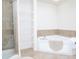 Bathroom with corner tub, shower, and shelving at 4177 N Orange Blossom Trl # 210, Orlando, FL 32804