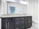 Bathroom boasts double vanity with granite top and dark wood cabinets at 623 Sylvan Ramble Rd, Davenport, FL 33837