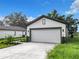 Modern house with a white exterior and a two-car garage at 623 Sylvan Ramble Rd, Davenport, FL 33837