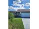 House exterior featuring a white garage and landscaping at 757 Caribou Dr, Kissimmee, FL 34759