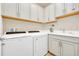 Bright laundry room with washer, dryer, cabinets, and utility sink at 356 Toldedo Rd, Davenport, FL 33837