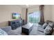 Living room with a gray sectional sofa, flat screen TV, and access to a balcony at 1301 Tuscan Ter # 9403, Davenport, FL 33896