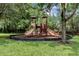 Enclosed playground with two play structures and wood-chip ground cover at 1301 Tuscan Ter # 9403, Davenport, FL 33896