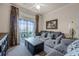 Living room features gray sofa, balcony access, and a coffee table at 1301 Tuscan Ter # 9403, Davenport, FL 33896