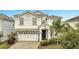 Two-story house with white exterior and a two-car garage at 8839 Interlocking Ct, Davenport, FL 33896