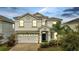Two-story house with white exterior and a two-car garage at 8839 Interlocking Ct, Davenport, FL 33896