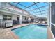 Resort-style pool with spa and screened enclosure; outdoor kitchen and lounge area at 8839 Interlocking Ct, Davenport, FL 33896