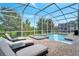 Relaxing pool and spa area with lounge chairs and screened enclosure at 8839 Interlocking Ct, Davenport, FL 33896